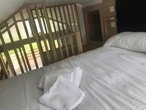 a white bed with white towels on top of it at Caledonian lodges 3 Inverness in Inverness