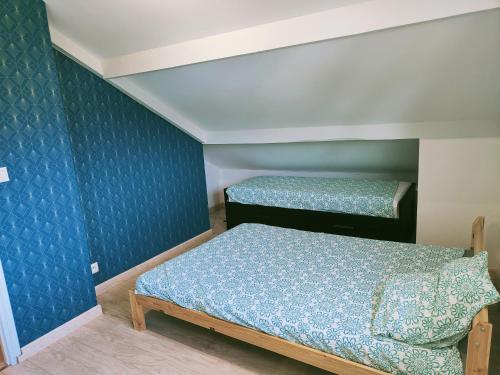 twee bedden in een kamer met blauwe muren bij Appartement à l'entrée des trois vallées des Pyrénées - 50m2 