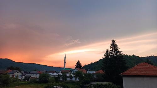 a sunset over a city with a tower in the distance at Apartman Adna in Kulen Vakuf