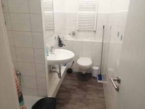 ein weißes Bad mit einem Waschbecken und einem WC in der Unterkunft Apartment Cologne in Köln