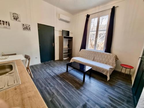 un salon avec un canapé et une fenêtre dans l'établissement Les Saules Studio Wifi Clim Gare Centre, à Avignon