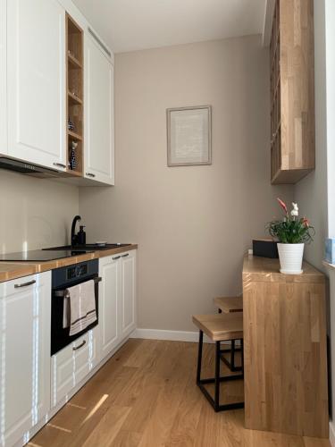a kitchen with white cabinets and a black stove at Apartament Perłowy in Zamość