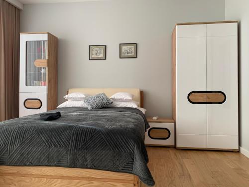 ein Schlafzimmer mit einem Bett und einem großen weißen Schrank in der Unterkunft Apartament Perłowy in Zamość