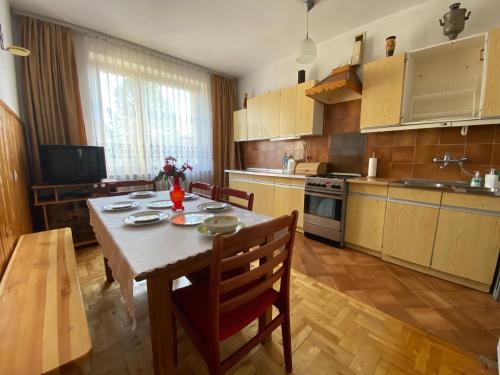uma cozinha com uma mesa e cadeiras e uma mesa e uma cozinha com uma mesa em Bella Casa Economy Villa - Skibowa, close to Bielany em Breslávia