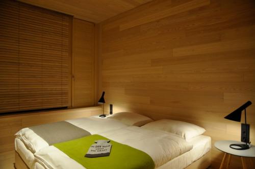 ein Schlafzimmer mit einem Bett mit einer grünen Decke darauf in der Unterkunft SEE 31, Ferienlofts am Traunsee in Traunkirchen