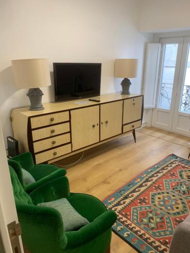 a living room with a television on a dresser at Casinhas Da Vila in Monção