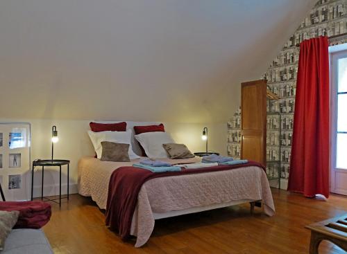 ein Schlafzimmer mit einem großen Bett mit roten Vorhängen in der Unterkunft La Ferme de la Fosse Dionne in Tonnerre