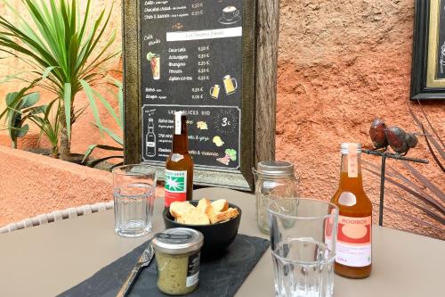 a table with two bottles of beer and a bowl of chips at Hotel Le Magnan in Avignon