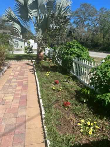 a garden with flowers and a white fence at Caribbean Splendor Vacation Rental near Bush Gardens Tampa FL in Tampa