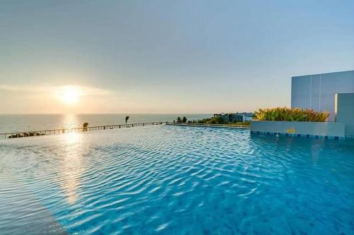 a large swimming pool with the ocean in the background at Love & Relax Balcony near WON Beach in Bangsaen