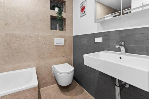 uma casa de banho com um lavatório branco e um WC. em Flatista Homes - Hirschgarten em Munique