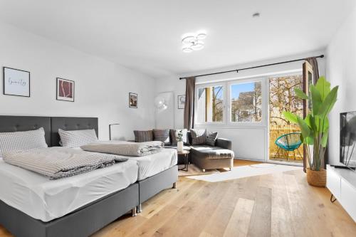 una camera con due letti e un soggiorno di Flatista Homes - Hirschgarten a Monaco