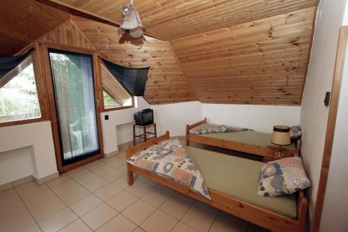 1 Schlafzimmer mit 2 Betten und einem TV in einer Hütte in der Unterkunft Vöröskő apartmanház in Révfülöp