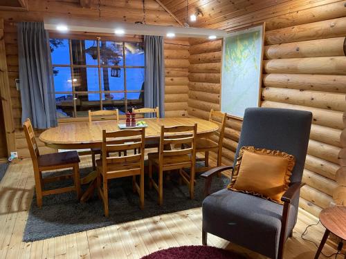 - une salle à manger en bois avec une table et des chaises dans l'établissement Vänvik Pyhtää, à Siltakylä