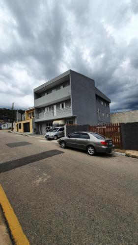 a parking lot with cars parked in front of a building at ACM Hotel in Aluminio