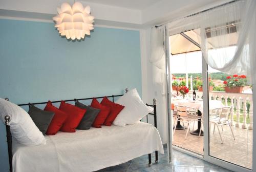 a bedroom with a bed with red and white pillows at Apartments Maria in Poreč