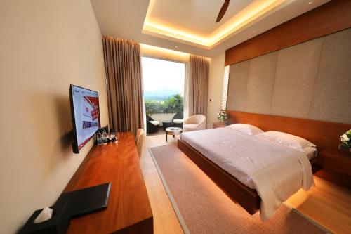 a bedroom with a bed and a large window at Grand Silver Ray in Ratnapura