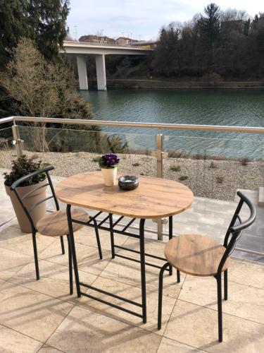 a wooden table and two chairs sitting on a patio at Maximo Apartments - free parking in Maribor