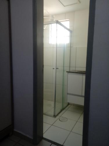uma casa de banho com um chuveiro e uma porta de vidro em Apartamento proximo ao shopping Franca em Franca