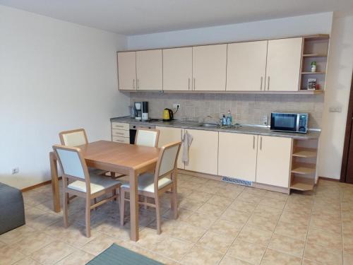 kuchnia ze stołem, krzesłami i kuchenką mikrofalową w obiekcie Free SPA Pirin lodge cosy apartment w mieście Bansko