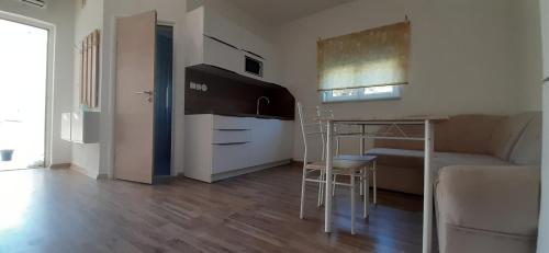 a room with a kitchen and a table and a couch at Apartments Barbic in Medulin