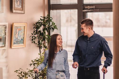 a man and a woman walking in a room at Business Hotel Plovdiv - Central Location in Plovdiv