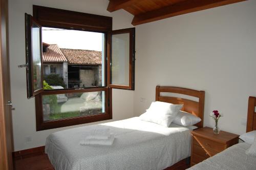 a bedroom with two beds and a large window at Gestiona2R - Casa El Refugio para 12 con finca en Llanes in Llanes
