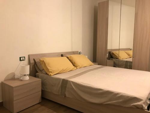 - une chambre avec un lit doté d'oreillers jaunes et d'un miroir dans l'établissement Da Piero e Lidia, à Iglesias