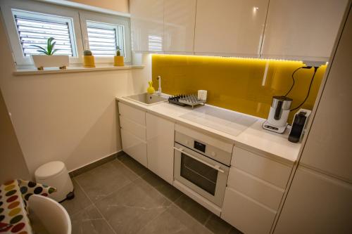 d'une cuisine avec un évier et un mur jaune. dans l'établissement Nook BB, à Split