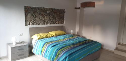 een slaapkamer met een bed met een kleurrijke deken bij CASA DEL LAGO in Travedona