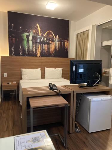 ブラジリアにあるHotel Águas Claras DFMrのベッドとテレビ付きの机のある部屋
