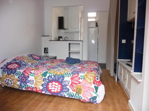 - une chambre avec un lit et une couverture colorée dans l'établissement Appart-Hotel T1 Lyon8 proche hopitaux, à Lyon