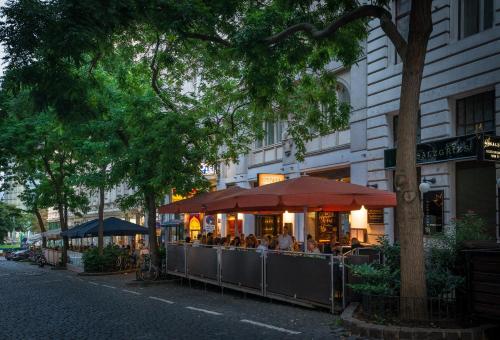 a restaurant with people sitting outside of a building at Hotel Marc Aurel - Vienna City Center in Vienna