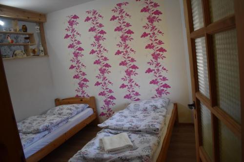 two beds in a room with flowers on the wall at Agroturystyka u Wioli i Irka , apartament u Beaty in Karsin