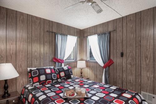 een slaapkamer met een bed met een tafel en 2 ramen bij McCarthy House, 3 Bedroom, Deck, Views, Sleeps 6, WiFi in Ruidoso