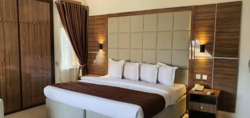 um quarto com uma cama grande num quarto de hotel em Presken Residence Annex em Ikeja