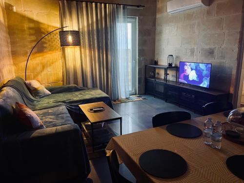 salon z kanapą i telewizorem w obiekcie Tac-Cnic Heritage Living - Apartment, Spa Suite & Spectacular Views w mieście Żebbuġ