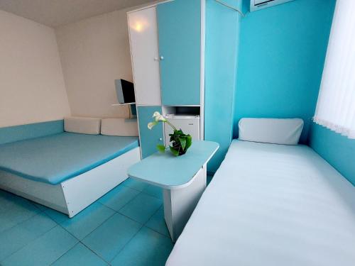 a small room with blue walls and a table and a desk at APARTMENT LEO 3 in Varna City