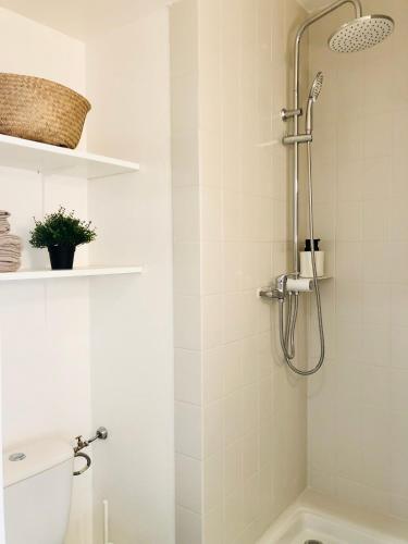 une salle de bain blanche avec douche et toilettes dans l'établissement Superbe appartement front de mer, à Villeneuve-Loubet