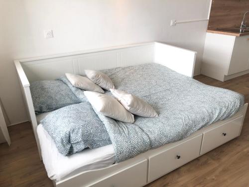 een wit bed met vier kussens erop bij Superbe appartement front de mer in Villeneuve-Loubet