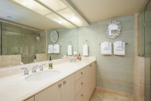La salle de bains est pourvue d'un lavabo et d'un grand miroir. dans l'établissement Sunrise Villa, à Ponte Vedra Beach