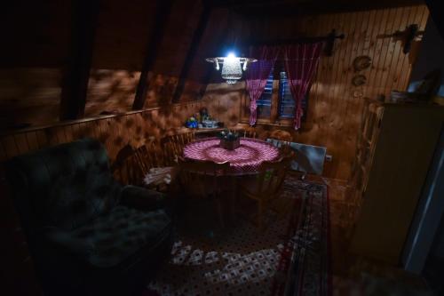 a dark room with a table and a chair at Vila Jovanovic in Zlatibor