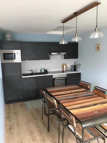 Il comprend une cuisine avec une table et des chaises en bois. dans l'établissement villa la marine, à Cayeux-sur-Mer