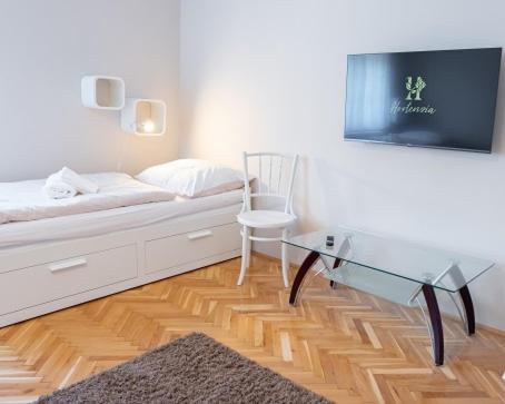 um quarto com uma cama com uma mesa de vidro e uma cadeira em Hortenzia Vendégház Mór em Mór