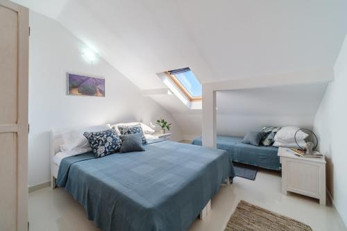 een witte slaapkamer met 2 bedden en een raam bij Luka's SEA View Terrace & Steps from the Beach apartment in Mirce