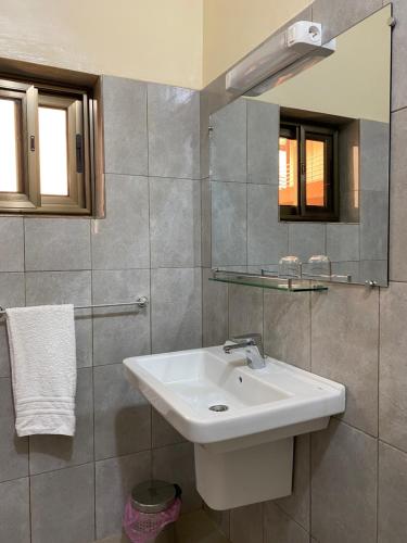 a bathroom with a sink and a mirror at Résidences Ouadada in Porto-Novo