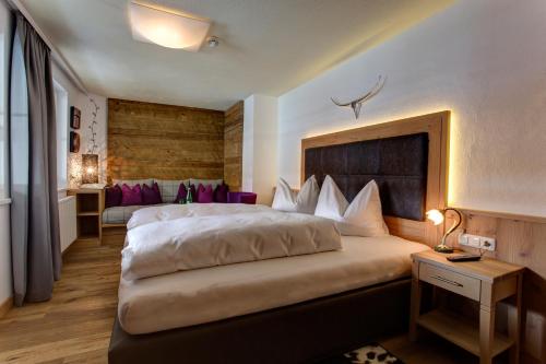 een hotelkamer met een groot bed en een bureau bij Hotel Garni - Restaurant Kaminstube in Sankt Anton am Arlberg