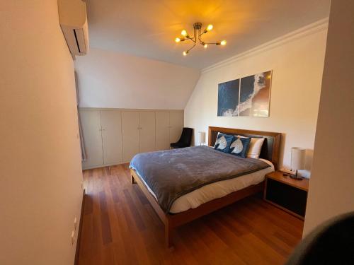 1 dormitorio con cama y lámpara de araña en Heart of Ocean Dulpex Estoril, en Estoril