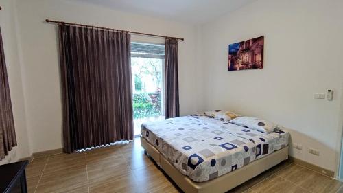 a bedroom with a bed and a large window at Happy house @ Casa Seaside Rayong in Ban Chak Phai