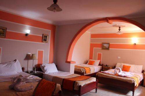 a hotel room with three beds and an archway at Osiris Hotel Cairo in Cairo